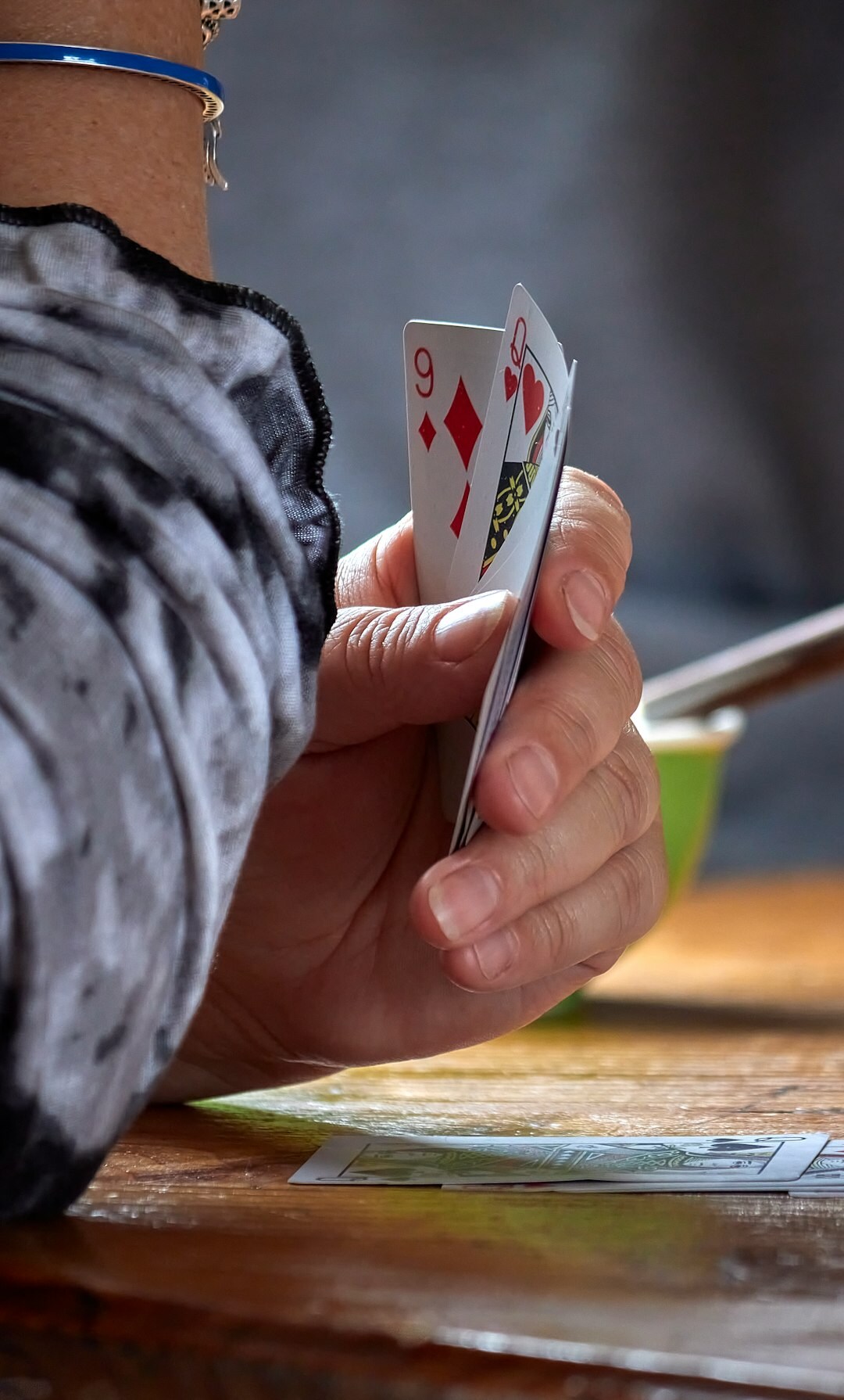 Two elderly women playing cards at a wooden table